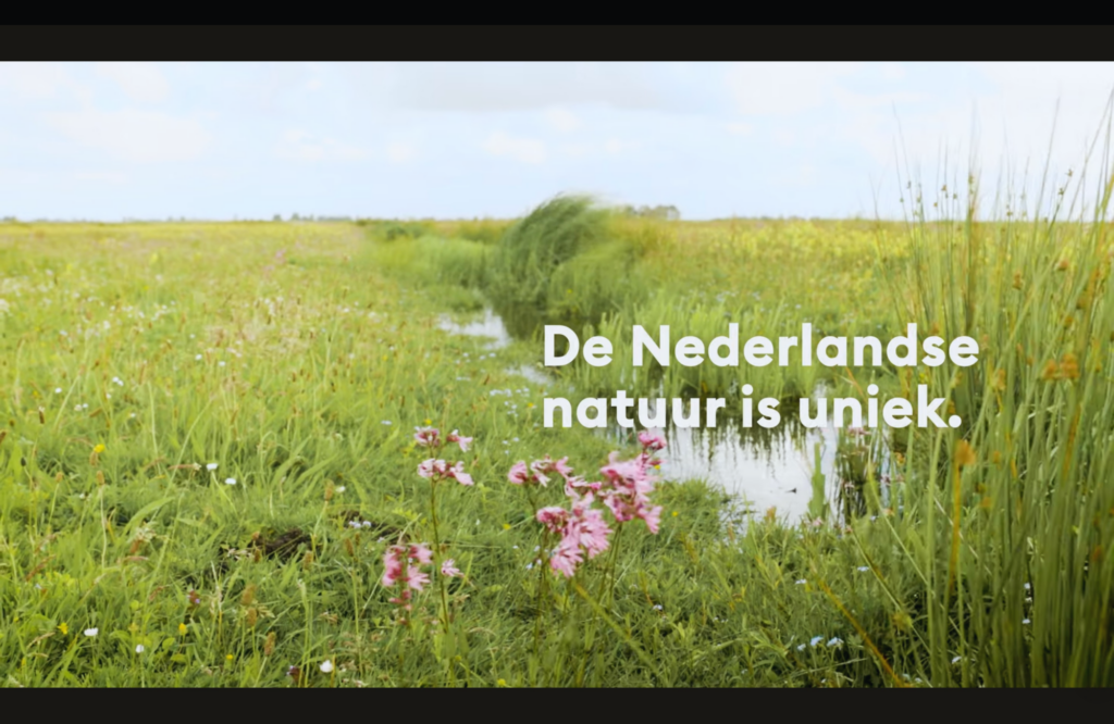een stilstaand beeld uit een bedrijfsvideo van Staatsbosbeheer. we zien een landschap met gras en sloten met tekst in beeld 'De Nederlandse natuur is uniek.' 
